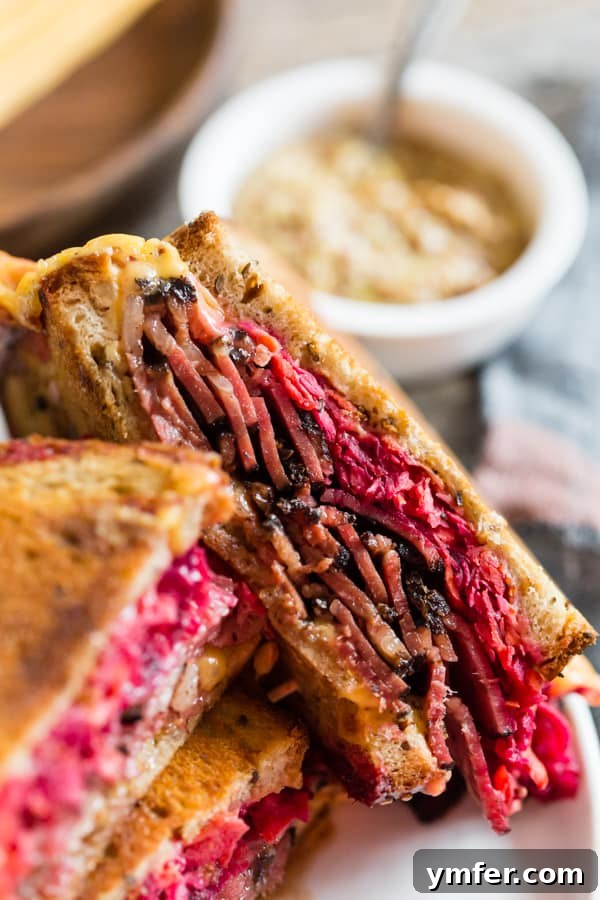 Grilled Pastrami and Root Slaw Sandwich 5 Grilled Pastrami Sandwich with Root Vegetable Slaw, cut in half to showcase its layers of pastrami, cheese, and vibrant slaw.