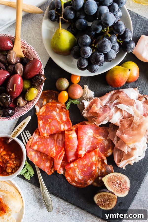 Gourmet Italian Antipasto Board 6 A close-up view of the Ultimate Italian Antipasto Platter, featuring an array of meticulously folded cured meats, colorful fruits, olives, and nuts, offering a feast for the eyes and palate.