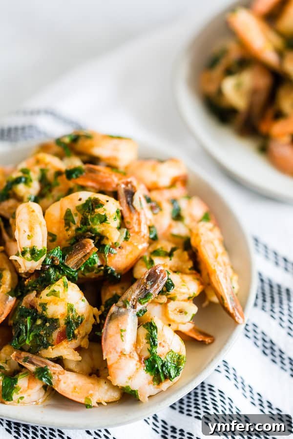 Hot Garlic Cilantro Shrimp 4 Close-up shot of Spicy Garlic Cilantro Shrimp in a serving bowl, beautifully arranged with scattered fresh garlic slices and cilantro leaves.