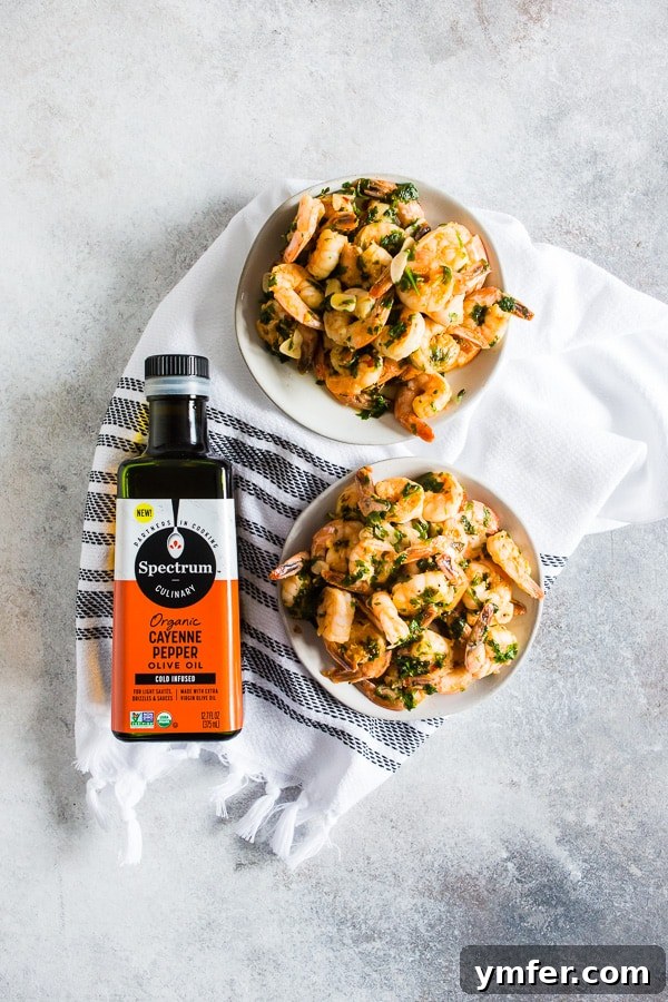 Hot Garlic Cilantro Shrimp 5 Spicy Garlic Cilantro Shrimp in a skillet positioned next to a bottle of Spectrum Organic Olive Oil, beautifully lit to showcase the freshness and key ingredients.