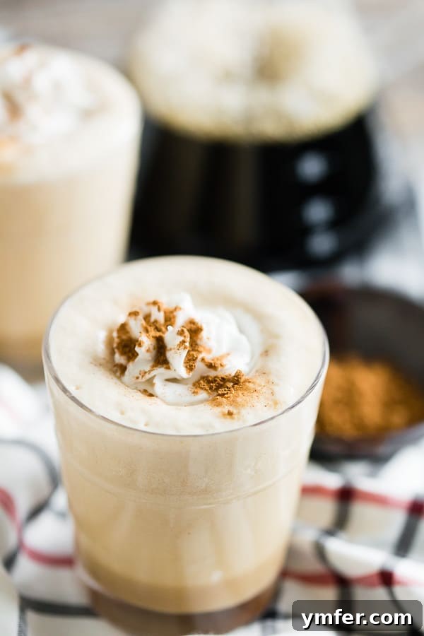 Pumpkin Spice Power Brew 3 A close-up of the Pumpkin Spice Coffee Protein Shake, topped with a generous swirl of whipped cream and a sprinkle of pumpkin pie spice, ready to be enjoyed.