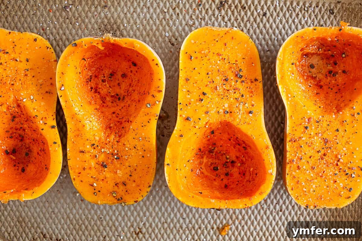 Savory Stuffed Honeynut Squash 3 Beautifully seasoned raw honeynut squash halves, brushed with olive oil and sprinkled with herbs, ready for roasting, showcasing their vibrant color and smooth texture.