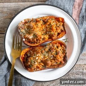 Savory Stuffed Honeynut Squash 7 A stuffed honeynut squash half on a white plate, showcasing the rich filling and golden roasted squash.