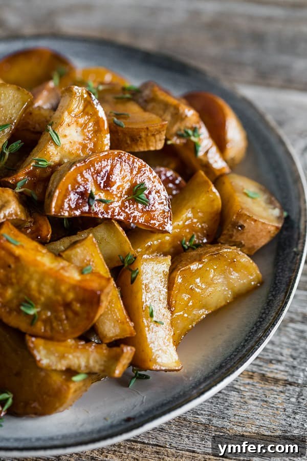 Roasted White Sweet Potatoes on a plate, garnished with fresh herbs.