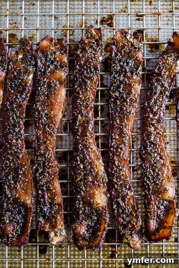 Maple Black Pepper Bacon, fully cooked and perfectly crispy, laid out on a sheet pan, ready to be enjoyed.