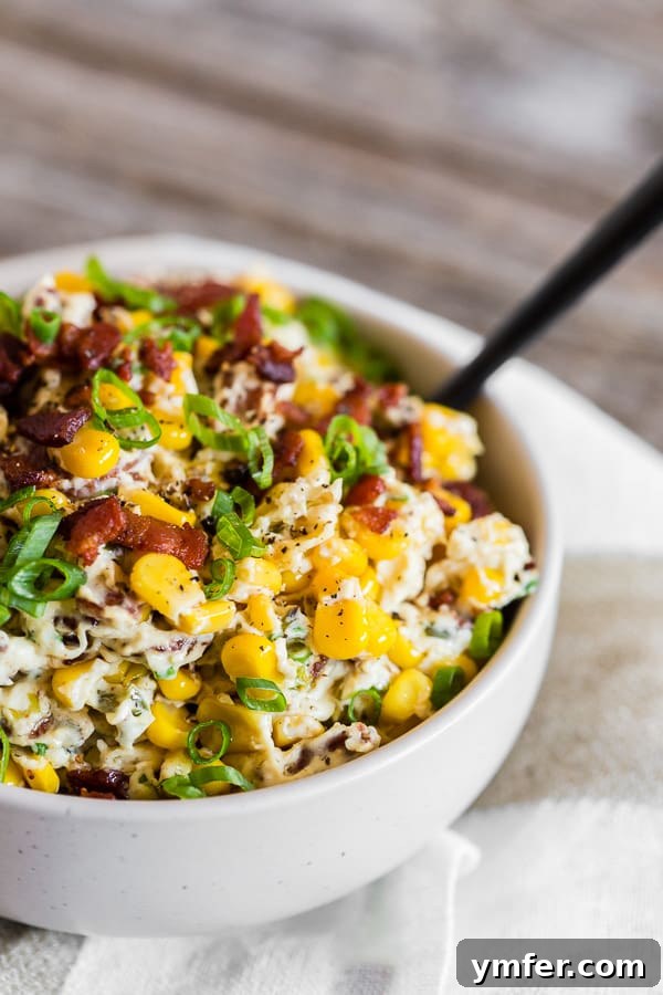 Zesty Bacon Creamy Corn Delight 2 Creamy Bacon Jalapeno Corn Dip in a white bowl, garnished with bacon and green onions.