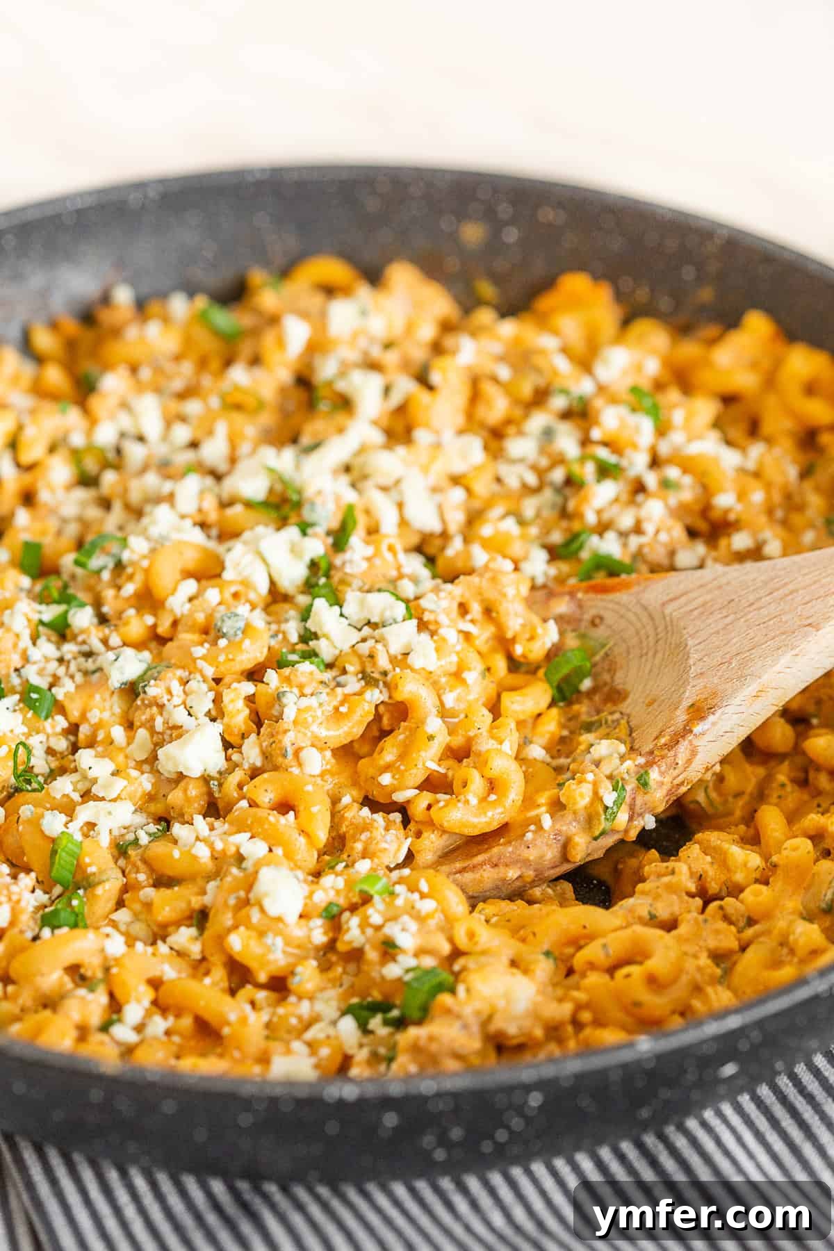Creamy One Pot Buffalo Chicken Pasta 4 Close-up view of One Pot Buffalo Chicken Pasta in a black skillet, with steam gently rising, ready to be served.