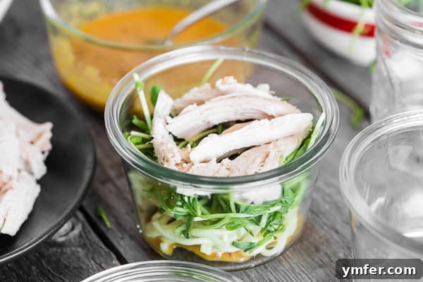 Instant Ramen Jars 6 Diced roasted chicken being added as a protein layer to a glass jar for a homemade cup of noodles.