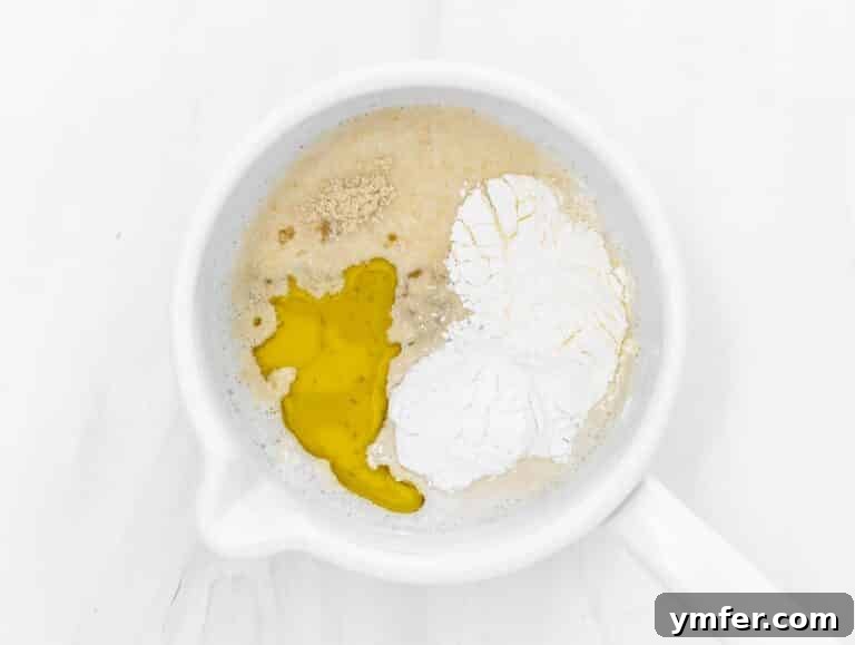 soy milk, cornstarch, potato starch, olive oil, salt and nutritional yeast in a pot, ready to be mixed