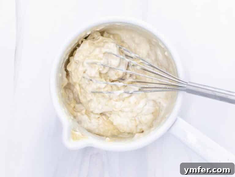 soy yogurt and lemon juice being added to the thickened mixture in the pot