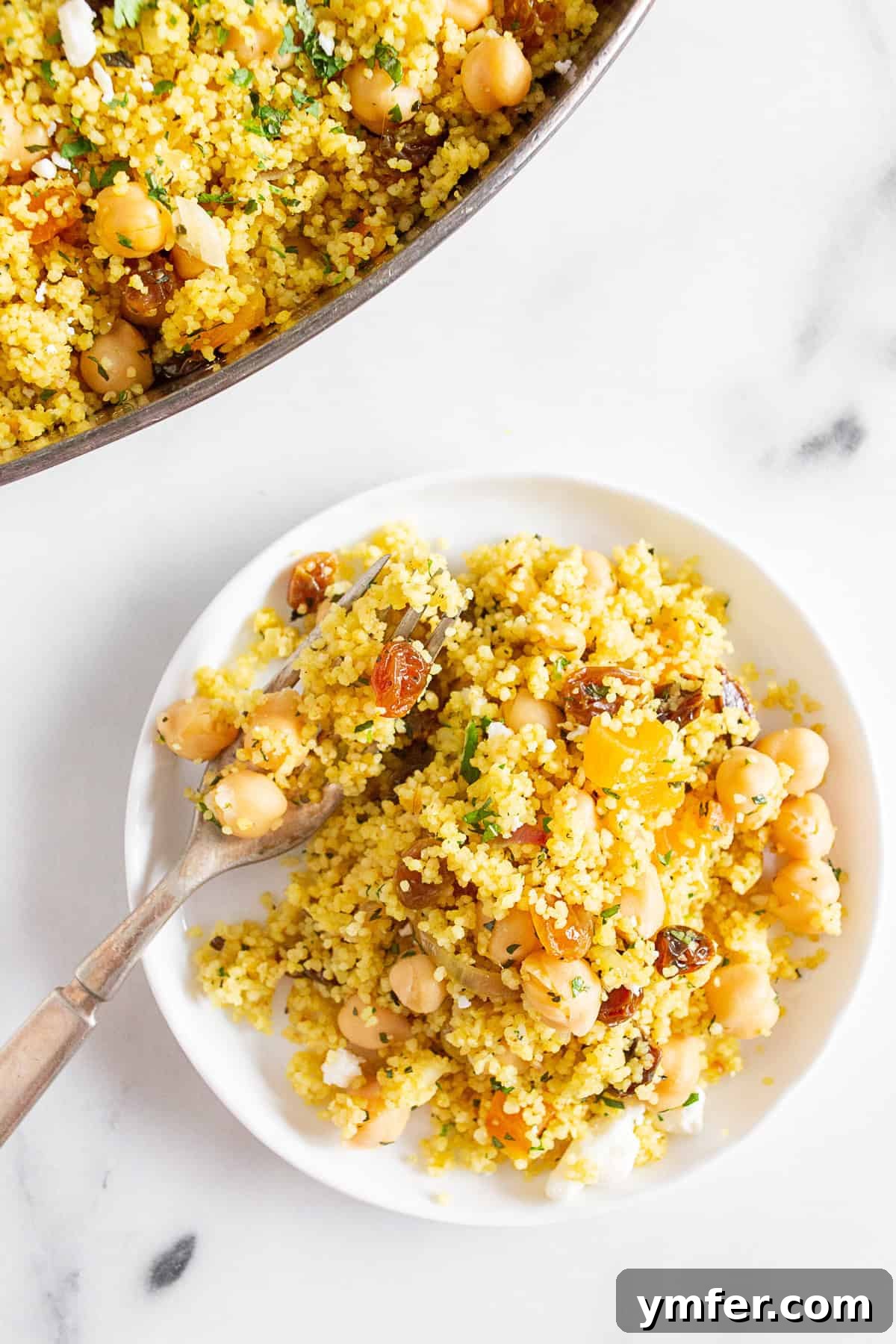 Vibrant Moroccan Chickpea Couscous 3 Moroccan Couscous on a plate with a fork, ready to be enjoyed.