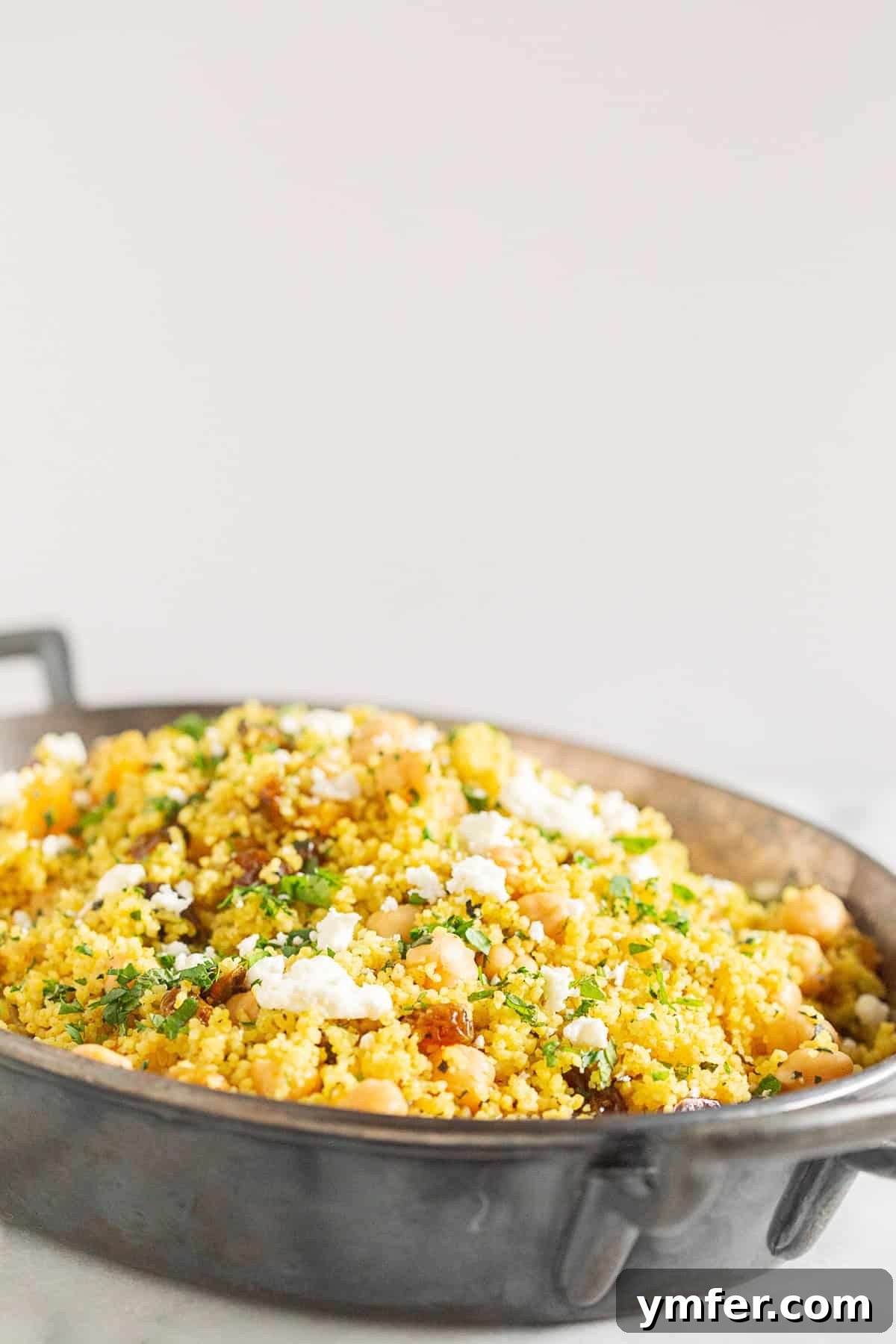 Vibrant Moroccan Chickpea Couscous 5 Moroccan Couscous topped with fresh herbs and crumbled feta cheese.