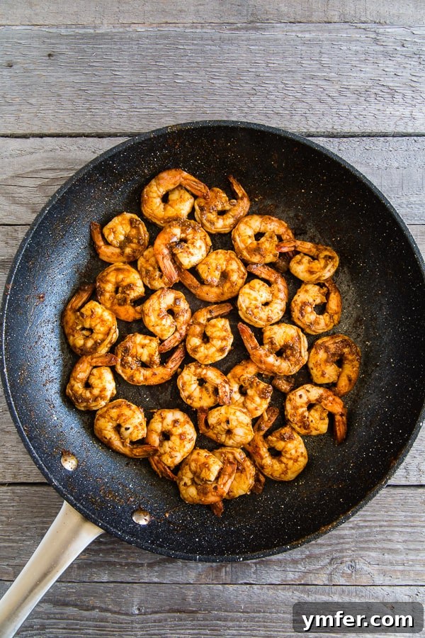Bold Chipotle Shrimp Fajita Bowls 5 Close-up of succulent chipotle lime shrimp sizzling in a hot skillet, showcasing the vibrant colors and appealing texture.