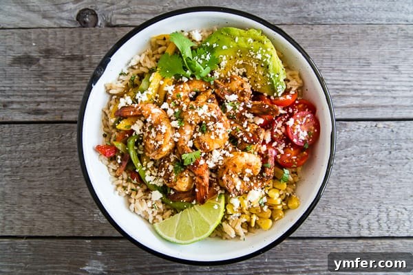 Bold Chipotle Shrimp Fajita Bowls 6 A vibrant Chipotle Shrimp Fajita Bowl generously drizzled with a light, creamy cilantro lime yogurt sauce, ready for serving.