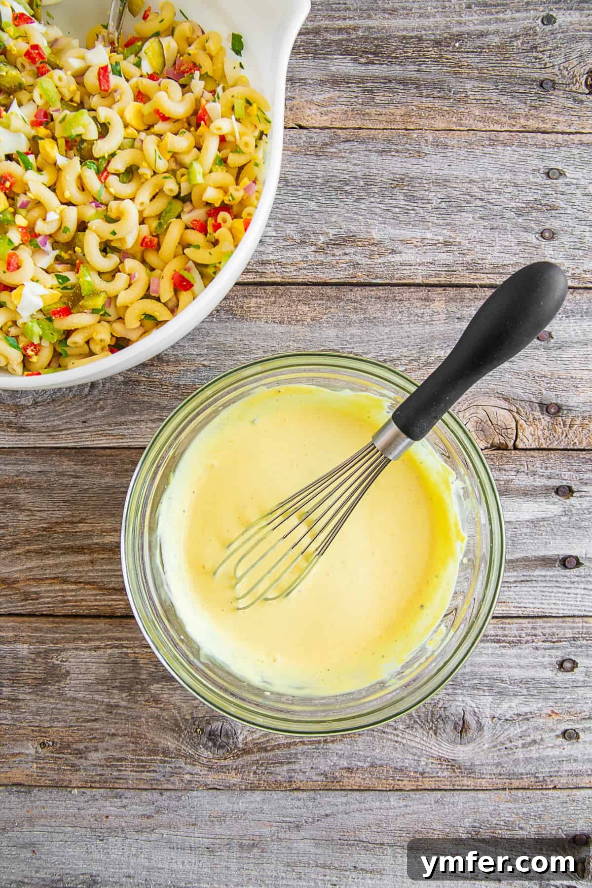 Grandma's Macaroni Salad 5 A bowl of creamy, yellow dressing for macaroni salad, showcasing its smooth texture.