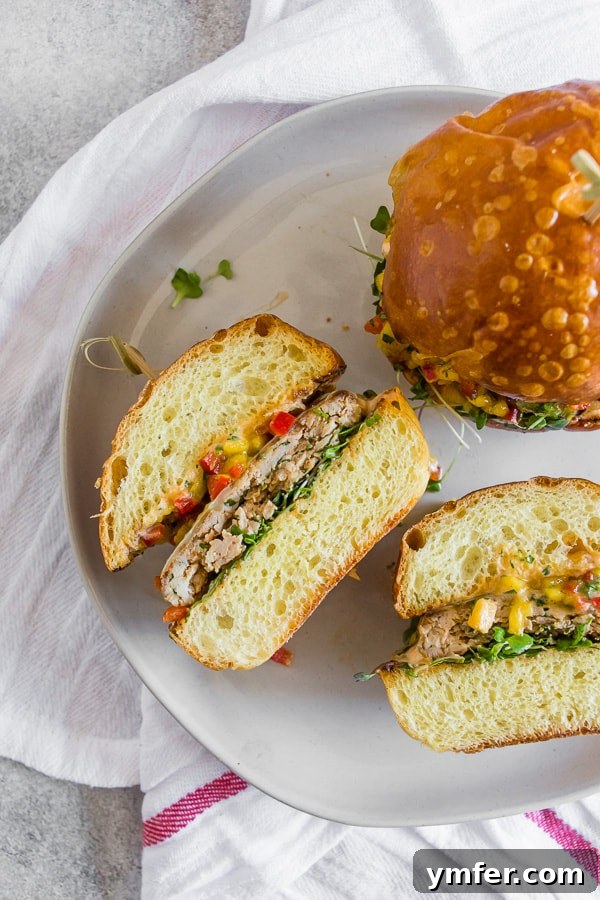 Chipotle Chicken Burgers Topped with Mango Salsa cut in half to show the burger. 