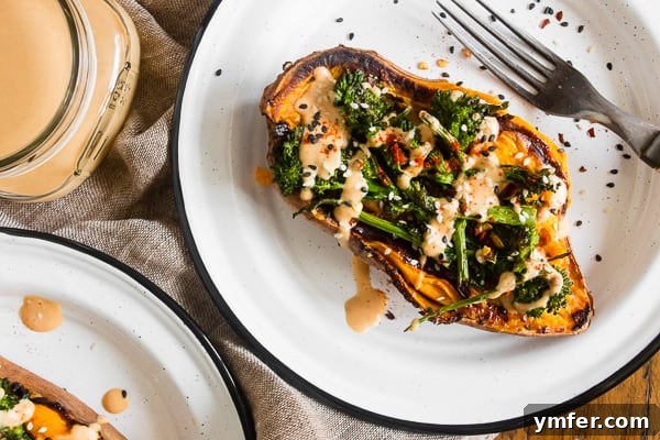 Loaded Sweet Potatoes with Broccoli Rabe and Hummus 6 A plate featuring broccoli rabe and hummus stuffed sweet potatoes, with a small bowl of extra hummus dressing on the side for dipping.
