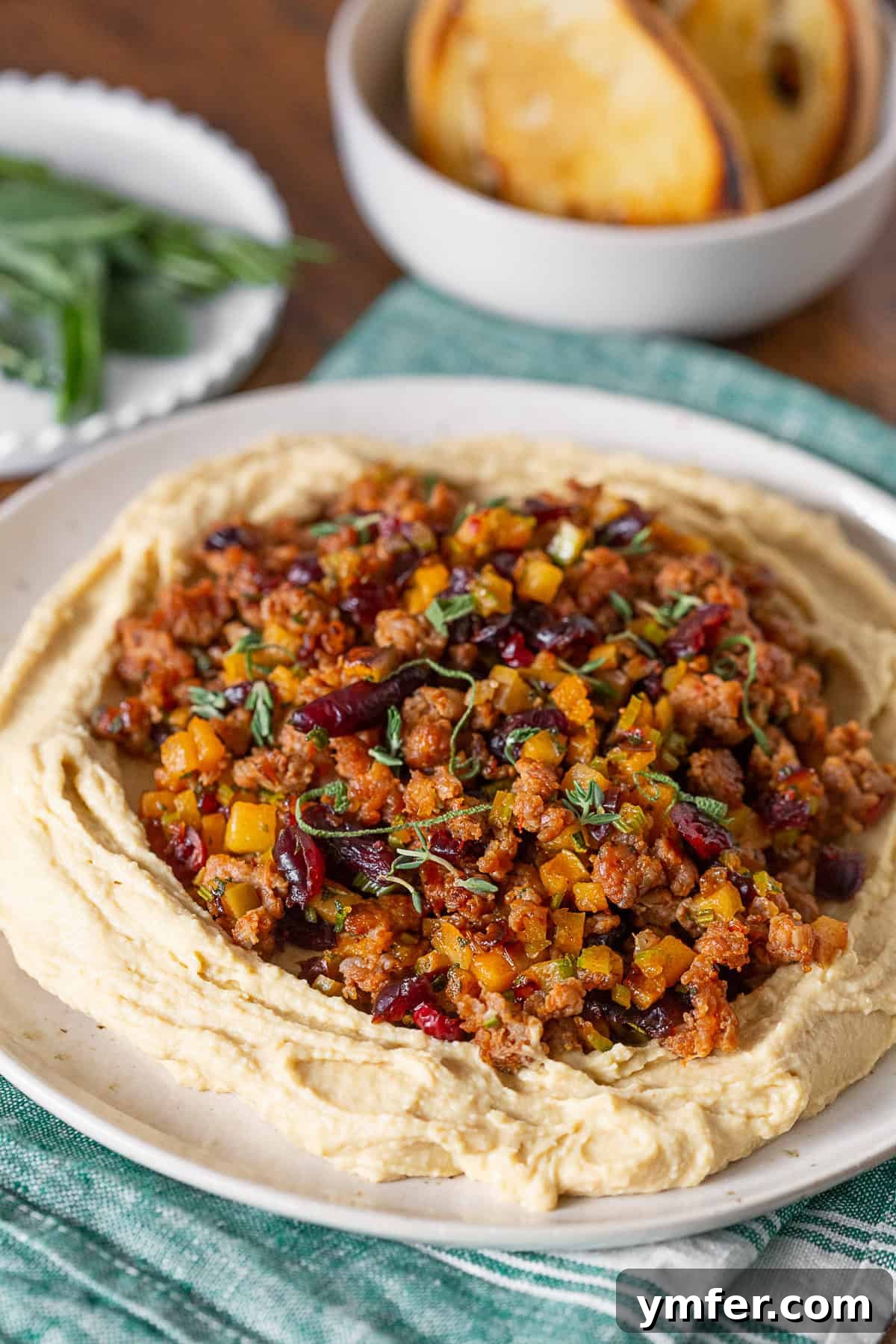 Stuffing Crusted Hummus 4 Thanksgiving Stuffing Topped Hummus on a plate with bread in the background and a festive napkin