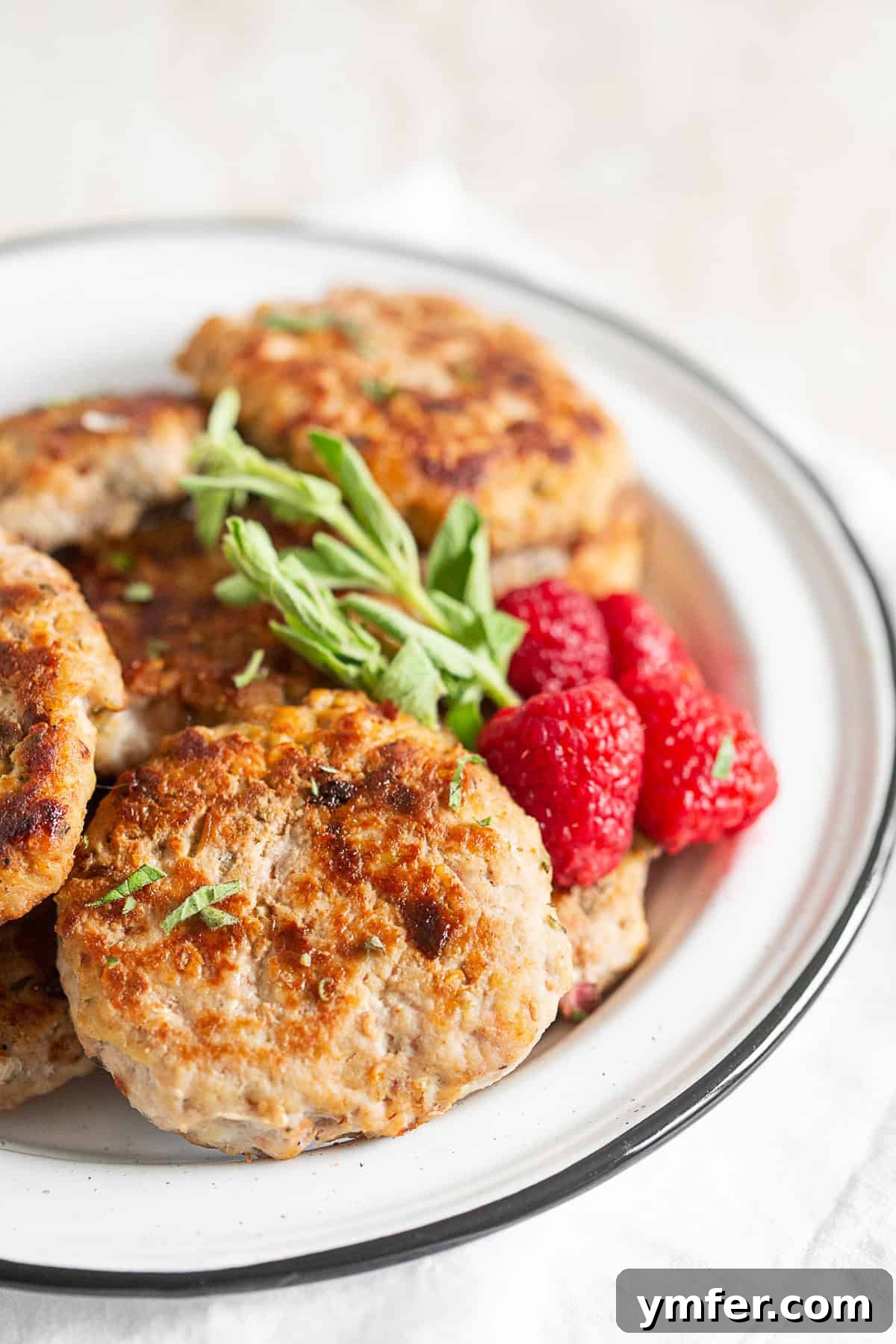 Handcrafted Chicken Sausage Patties 3 Homemade Chicken Sausage Patties served with raspberries.