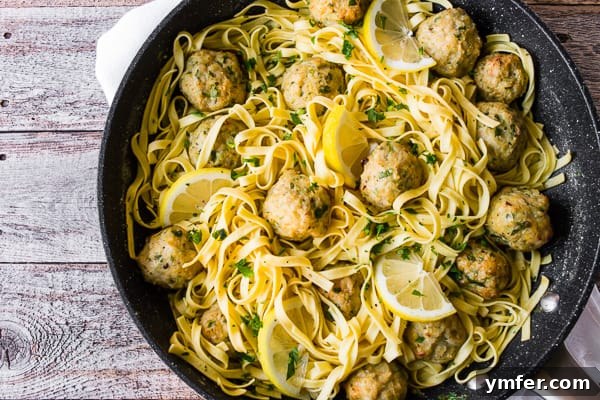 Zesty Baked Chicken Francese Meatballs 6 Baked Chicken Francese Meatballs in a skillet with pasta and sauce, ready to serve