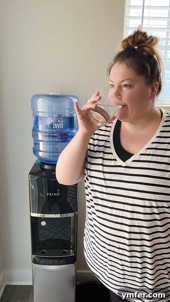 5 Easy Hacks to Boost Your Water Intake 3 A person holding a clear glass of water, symbolizing the act of drinking and staying hydrated.