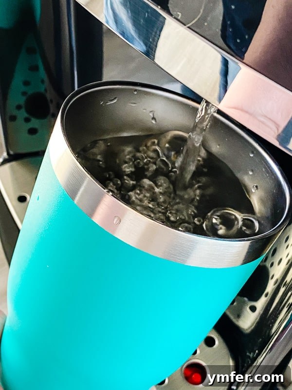 5 Easy Hacks to Boost Your Water Intake 4 A close-up shot of water being poured into a clear glass, highlighting the simplicity and refreshing nature of pure water.