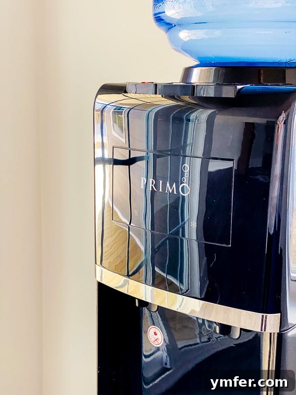 5 Easy Hacks to Boost Your Water Intake 6 A person working at a desk with a glass of water nearby, symbolizing the importance of keeping water accessible throughout the day.