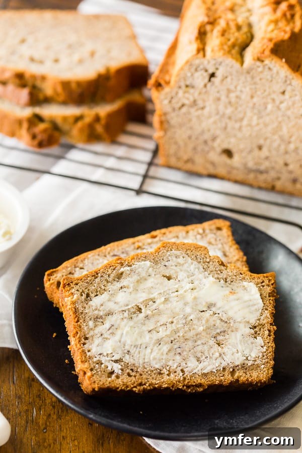Tangy Sourdough Banana Loaf 5 A slice of sourdough banana bread topped with a generous spread of butter, ready to be enjoyed.