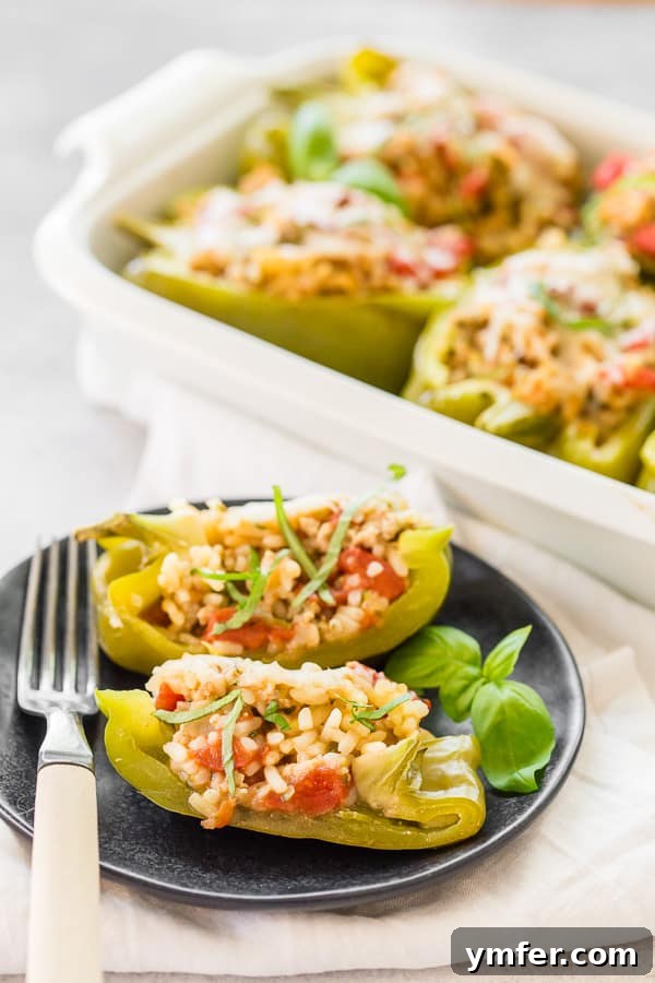 Savory Chicken Stuffed Bell Peppers 3 A halved Ground Chicken Stuffed Bell Pepper presented on a small plate with a fork, revealing the delicious, seasoned filling