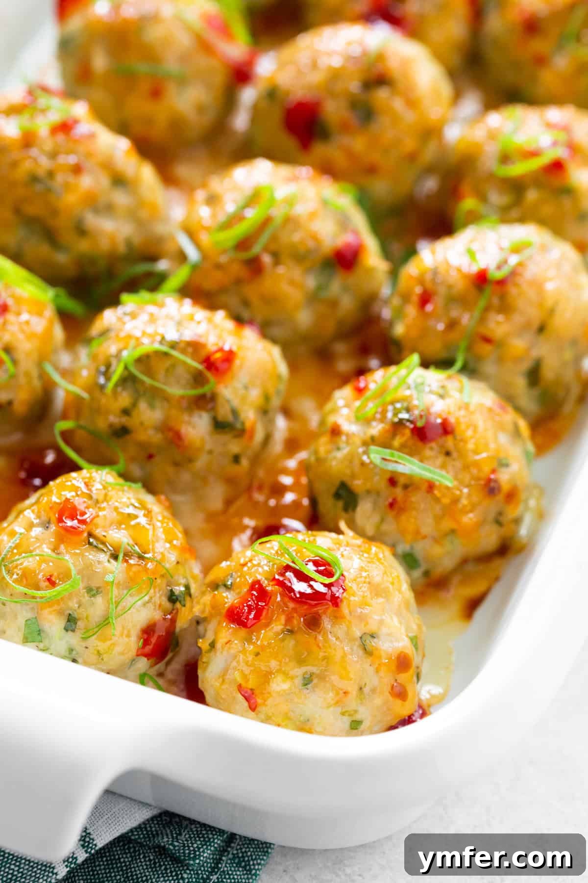Effortless Thai Baked Chicken Meatballs 4 Easy Thai Baked Chicken Meatballs garnished with green onion and cilantro.