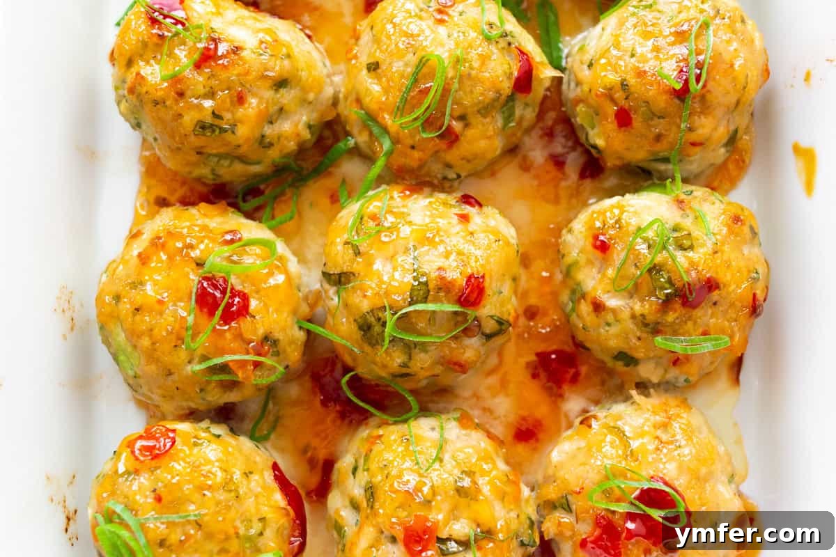 Effortless Thai Baked Chicken Meatballs 5 Easy Thai Baked Chicken Meatballs glazed with sweet chili sauce in a dish.
