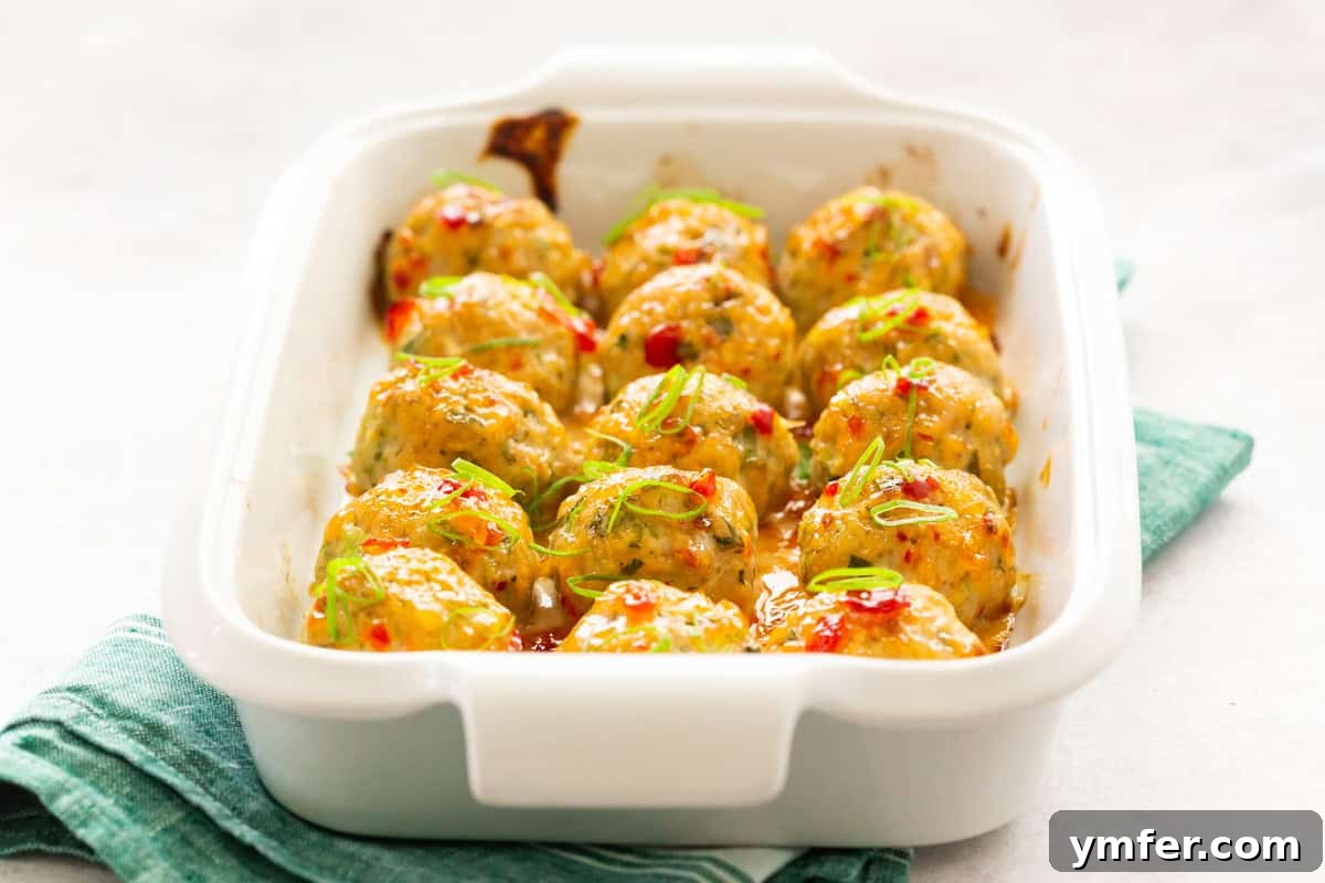 Effortless Thai Baked Chicken Meatballs 8 Easy Thai Baked Chicken Meatballs served in a dish with extra sauce.