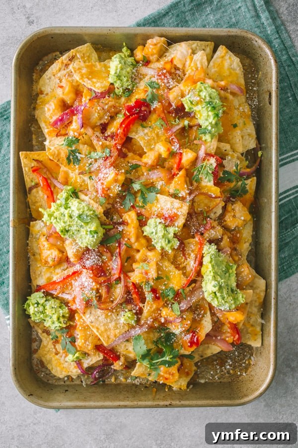 Sweet Heat Thai Chicken Nachos 2 Thai sweet chili chicken nachos on a small sheetpan with fresh toppings.