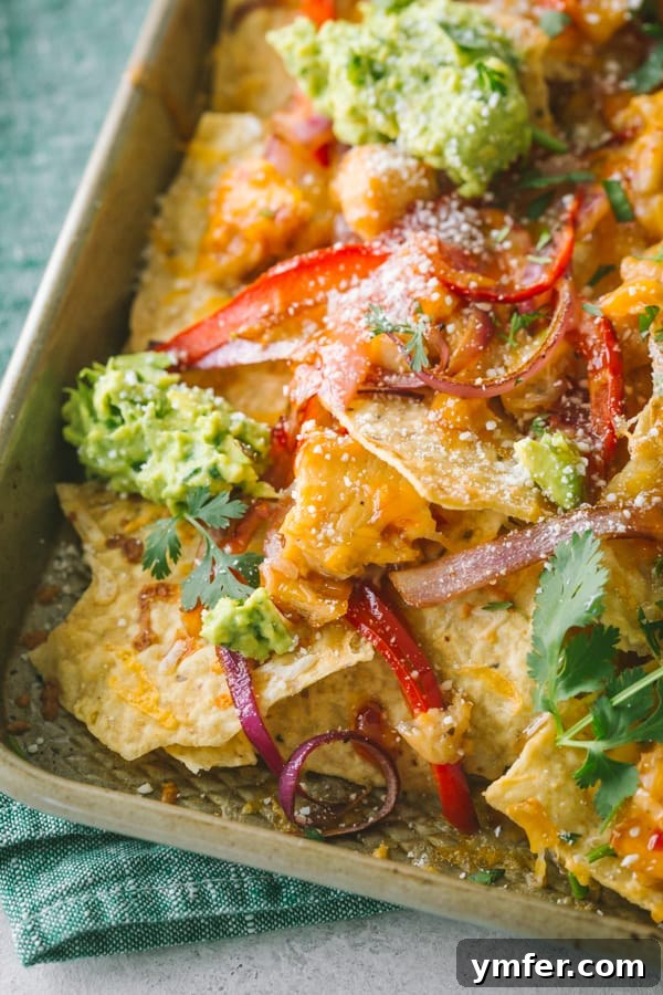 Sweet Heat Thai Chicken Nachos 3 Sweet chili chicken nachos on a sheet pan topped with fresh guacamole and cilantro.