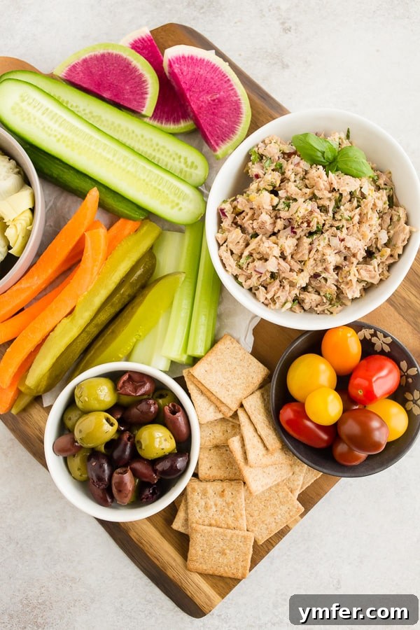 Zesty Tuna & Herb Grazing Board 6 lemon herb tuna salad in a white bowl surrounded by fresh veggies and crackers