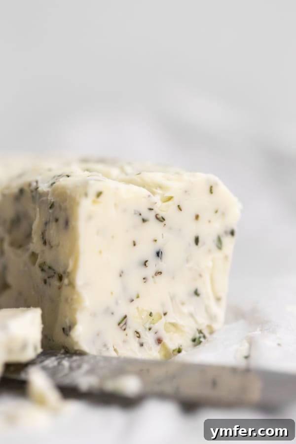 garlic herb compound butter sitting on parchment paper
