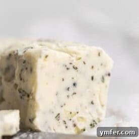 garlic herb compound butter sitting on parchment paper