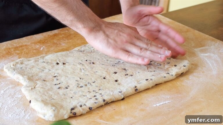 Rolling out brioche dough into a rectangular shape on a floured surface