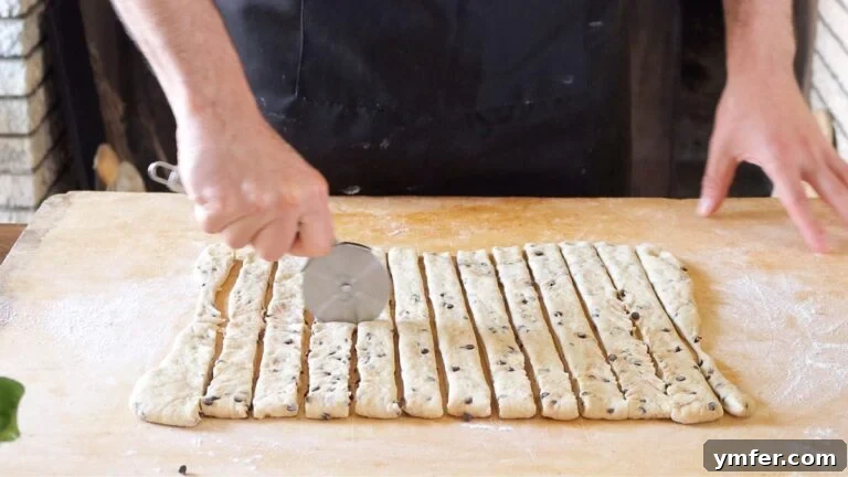 Cutting the brioche dough into even strips using a pizza cutter