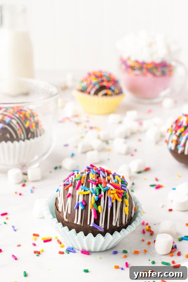 Sprinkle Surprise Strawberry Chocolate Hot Cocoa Bombs 2 Sweet chocolate strawberry funfetti hot chocolate bombs adorned with sprinkles, sitting on a rustic wooden table, promising a delightful treat.
