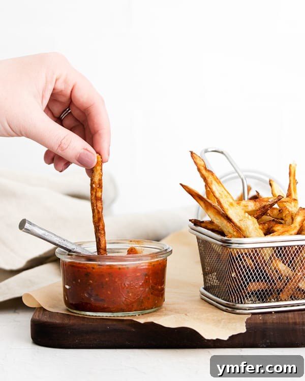 Crispy Air Fryer Garlic Parmesan Fries 4 Garlic Parmesan Air Fryer French Fries being dipped into ketchup