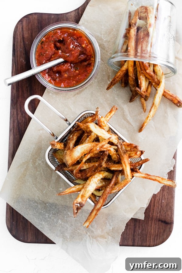 Crispy Air Fryer Garlic Parmesan Fries 5 Garlic Parmesan Air Fryer French Fries on a table with ketchup for dipping