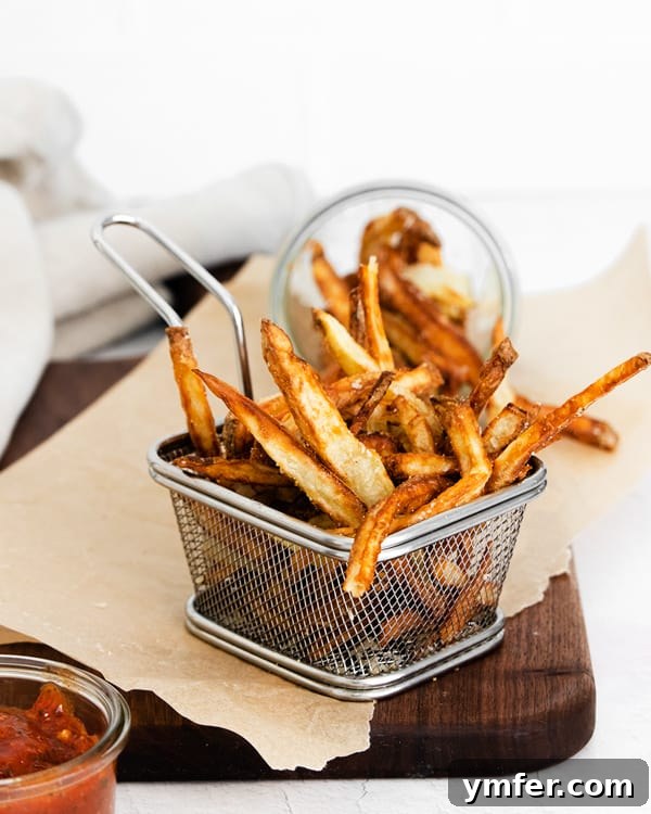 Crispy Air Fryer Garlic Parmesan Fries 6 Garlic Parmesan Air Fryer French Fries in a basket, ready to serve