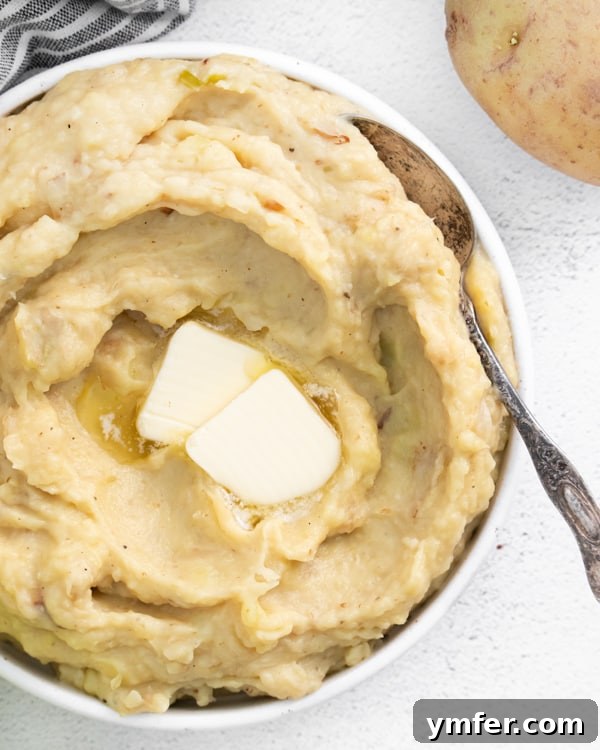 Creamy Instant Pot Colcannon 5 A serving of Instant Pot Colcannon Potatoes with a pat of butter melting on top, garnished with fresh herbs.