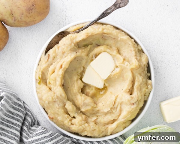 Creamy Instant Pot Colcannon 7 A close-up of a rustic spoon scooping Instant Pot Colcannon Potatoes from a bowl.