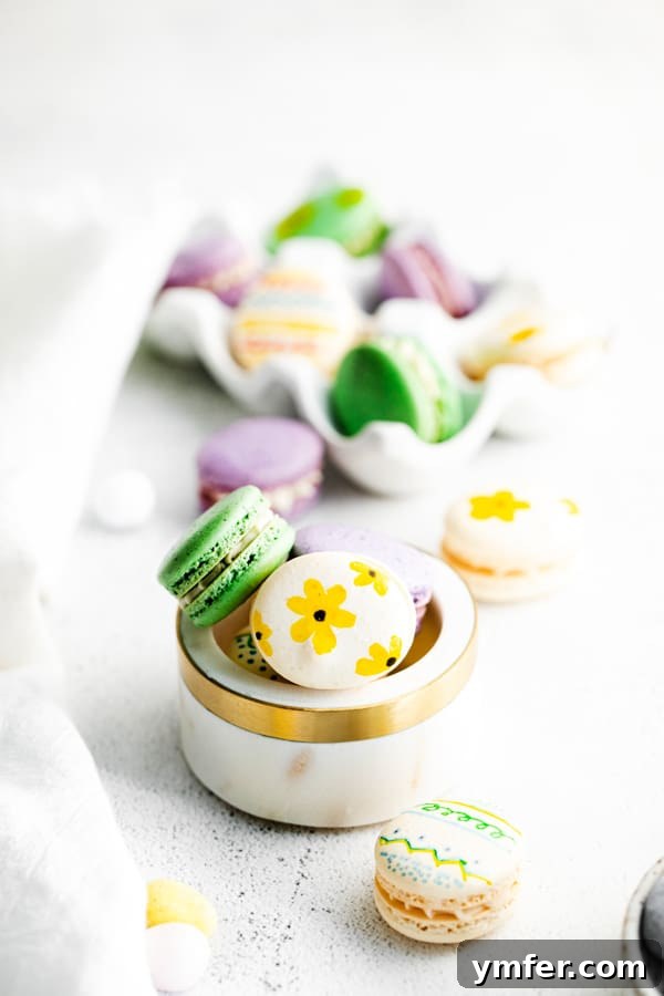 Pastel Easter Macarons 2 A charming white bowl overflowing with beautifully decorated Easter egg macarons, showcasing their delicate feet and soft pastel colors.