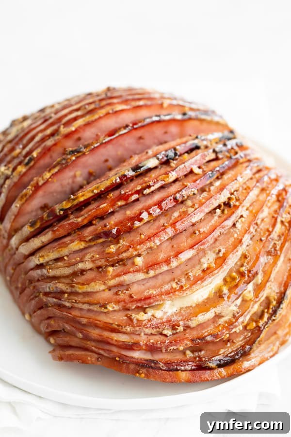 Honey Mustard Glazed Spiral Ham 3 Spiral slices of Honey Mustard Baked Ham arranged enticingly on a white plate, highlighting the delicious glaze.