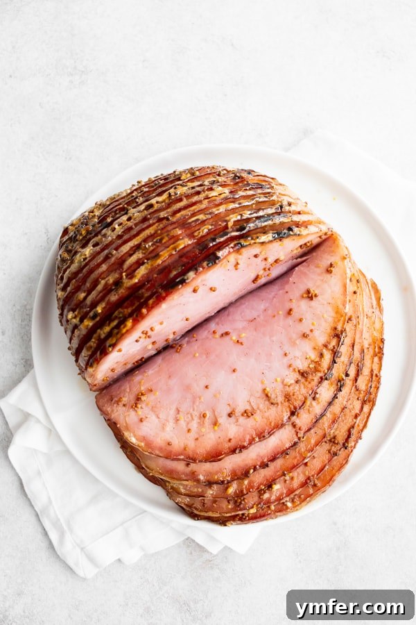 Honey Mustard Glazed Spiral Ham 6 A perfectly cooked honey mustard spiral ham, cut open to reveal juicy, tender slices, ready to be served.