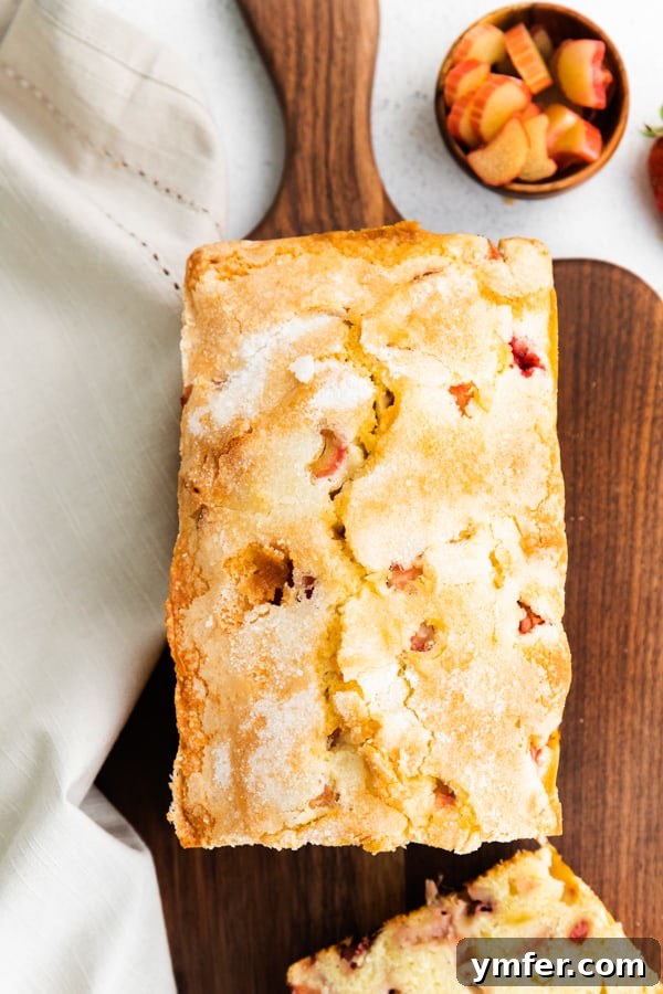 Sweet & Tangy Strawberry Rhubarb Pound Cake 5 The top of a baked strawberry rhubarb pound cake, showcasing its golden-brown, lightly cracked, and perfectly sugary crust.