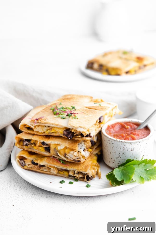 One-Pan Chicken Quesadillas 3 A stack of golden-brown sheet pan chicken quesadillas, showcasing the delicious layers inside.